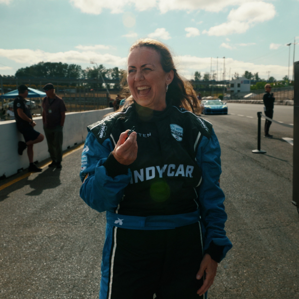 Julie laughing in her INDYCAR firesuit on pit lane
