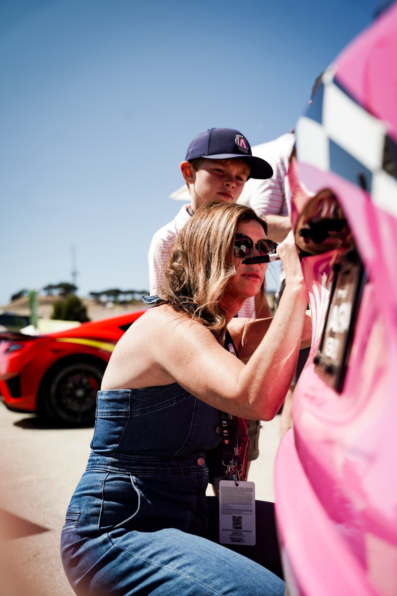 A fan signing the pink Drive for the Cure car