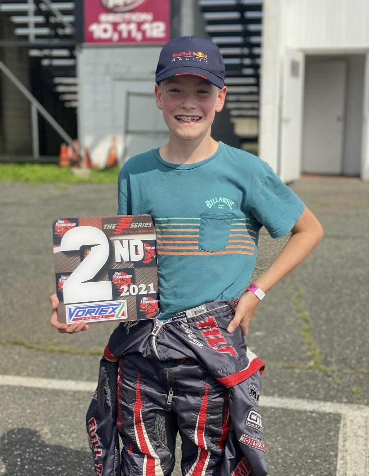 Max Taylor as a young karter with a runner-up trophy plaque